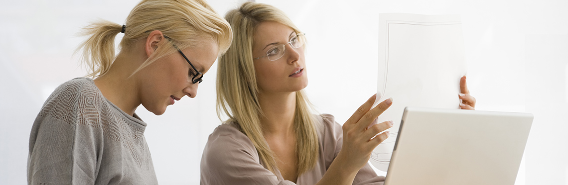 Two women working together and looking at documents