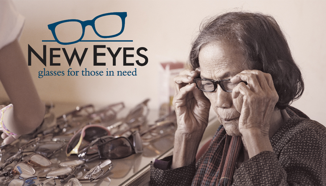 Image of elderly woman putting glasses on