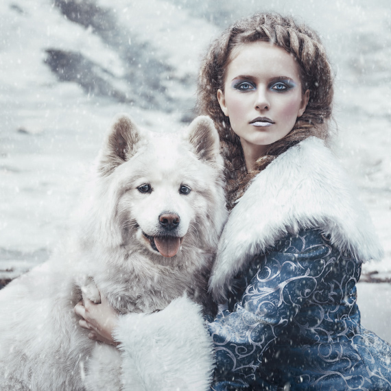Medieval or renaissance style woman in the snow with a Samoyed dog, in a Game of Thrones style