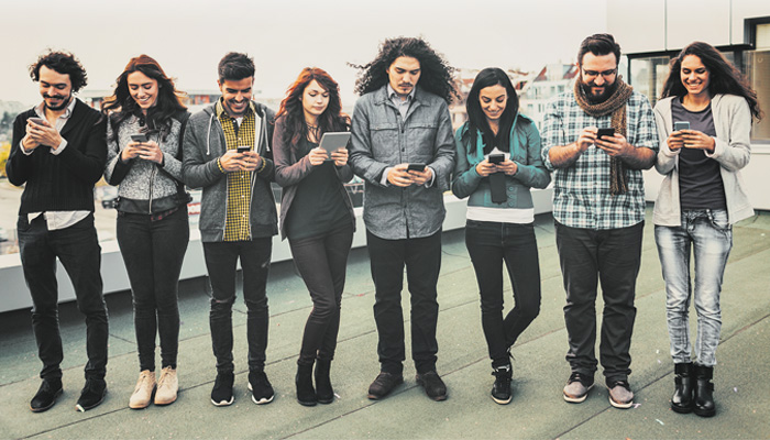 "Whippersnappers" image for "One Site to Rule them All" article. Group of eight people all looking at their phones.